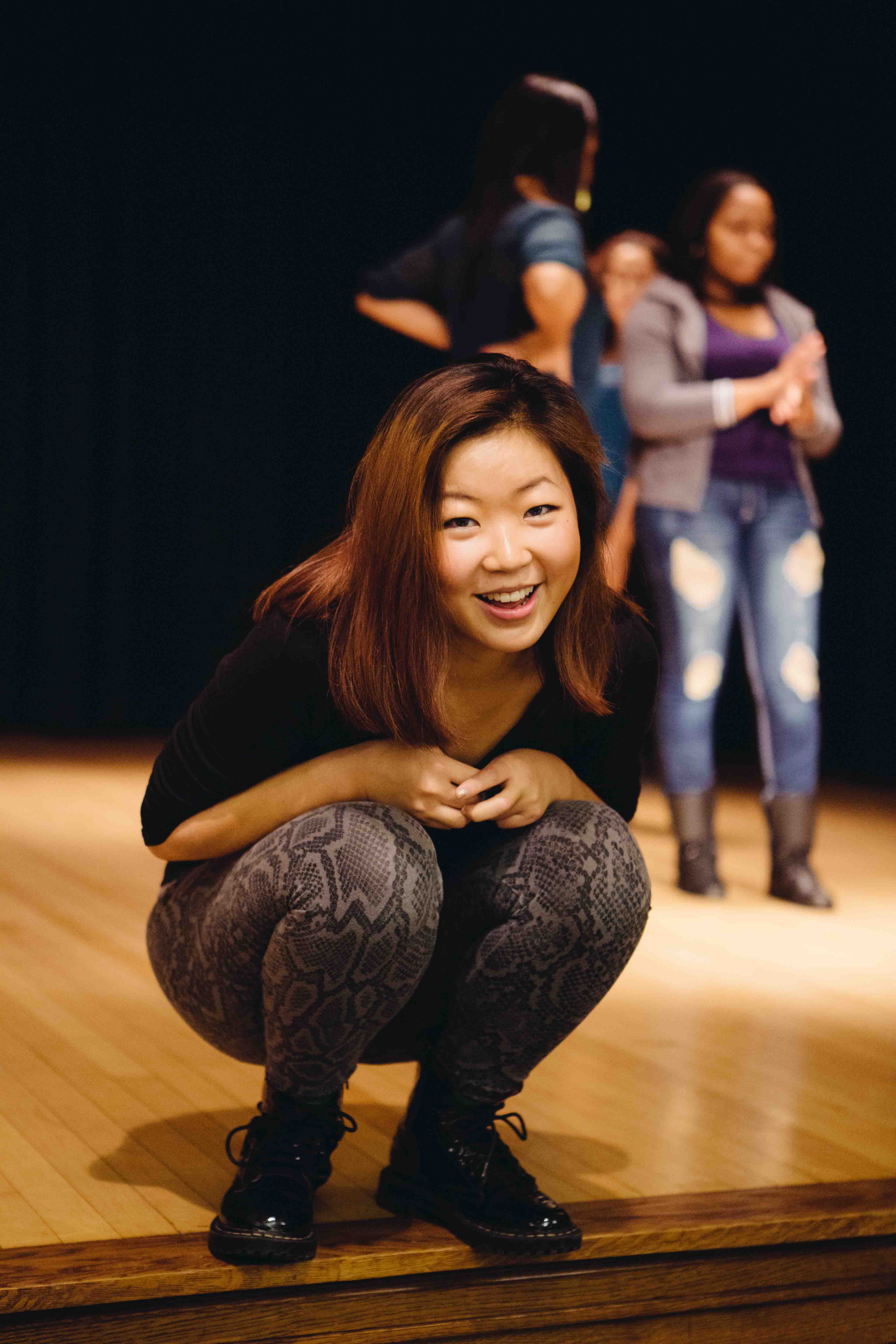 College student laughing on stage in campus theater.