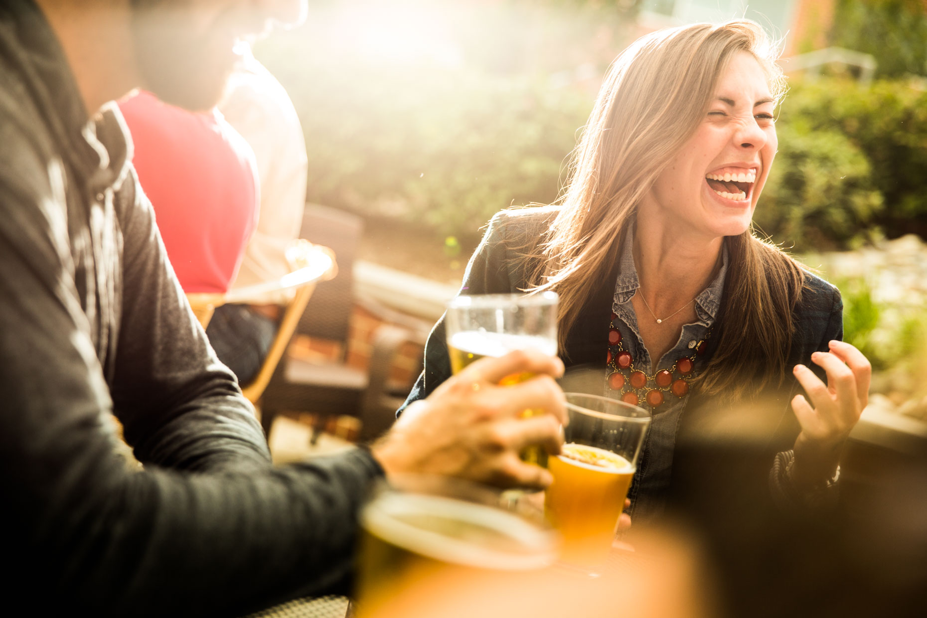 Female laughing with beer outside
