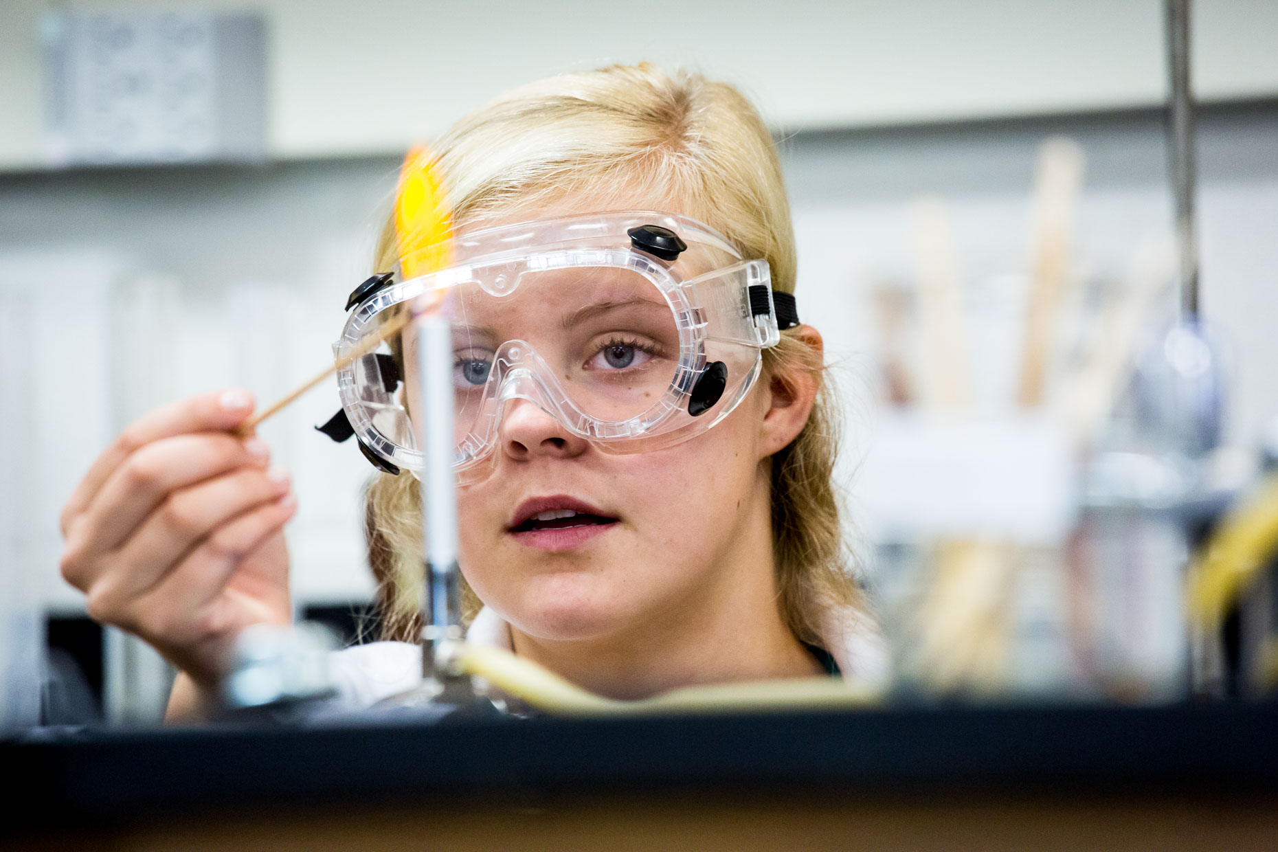 Girl using Bunsen Burner in science lab.