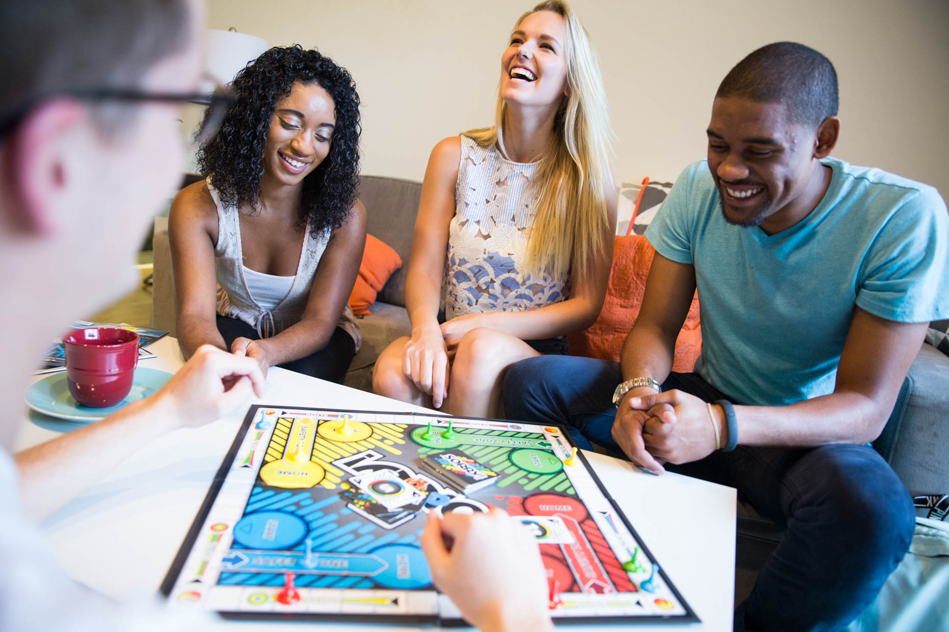 College students playing a board game in dorm room.
