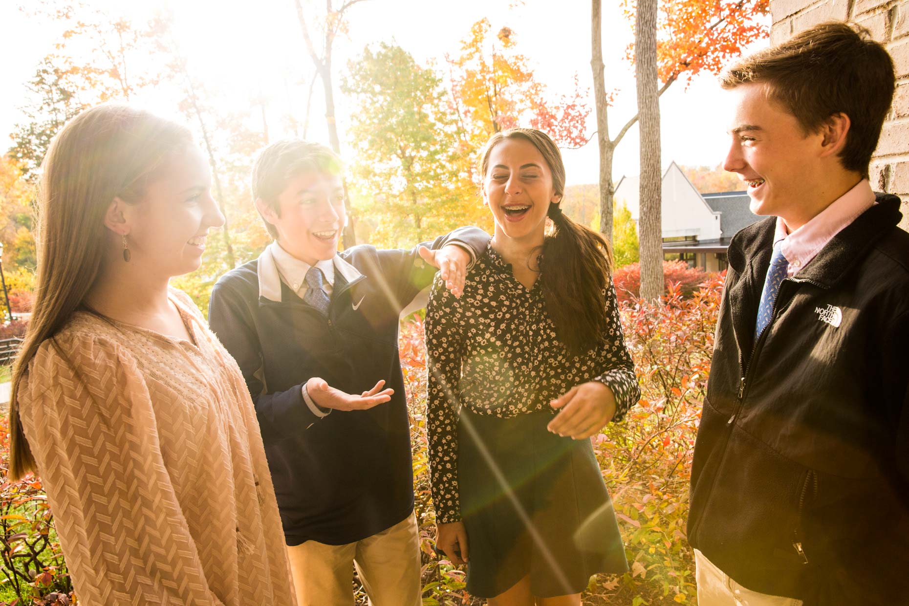 Students laughing outside with sun flare