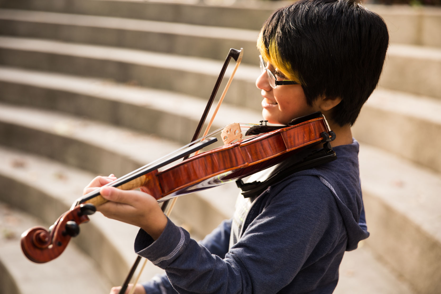 Student playing violin in amphitheater