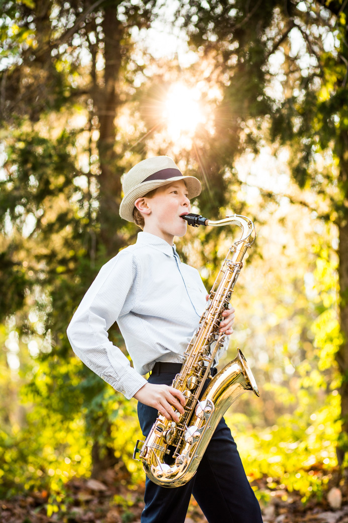 Boy in hat playing saxophone outside