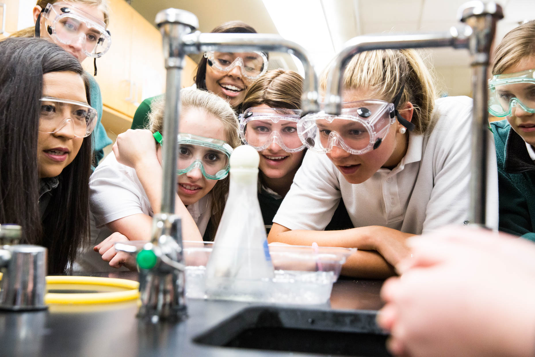 Girls in science lab wearing safety goggles.