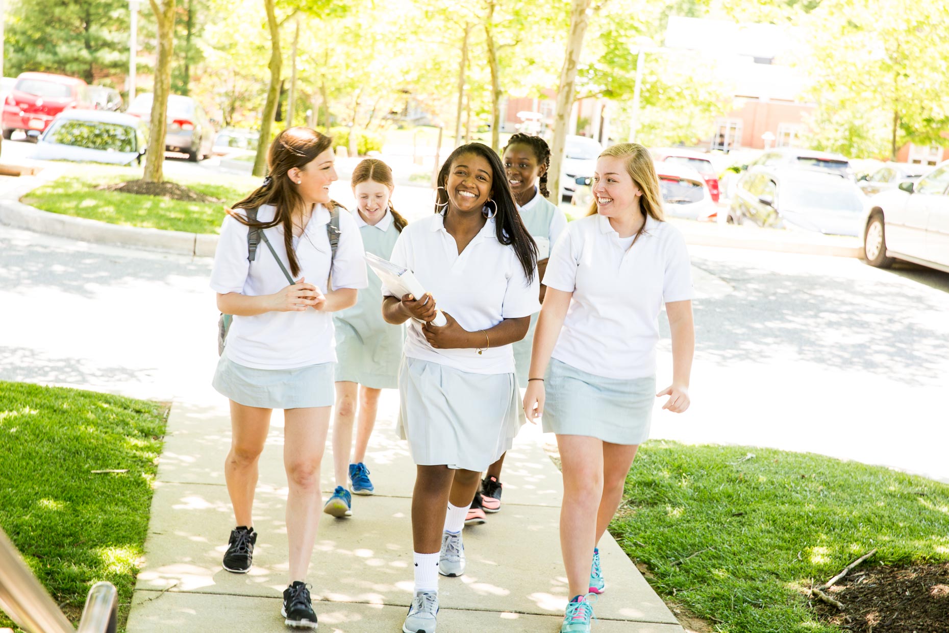 Smiling female students walking outside.