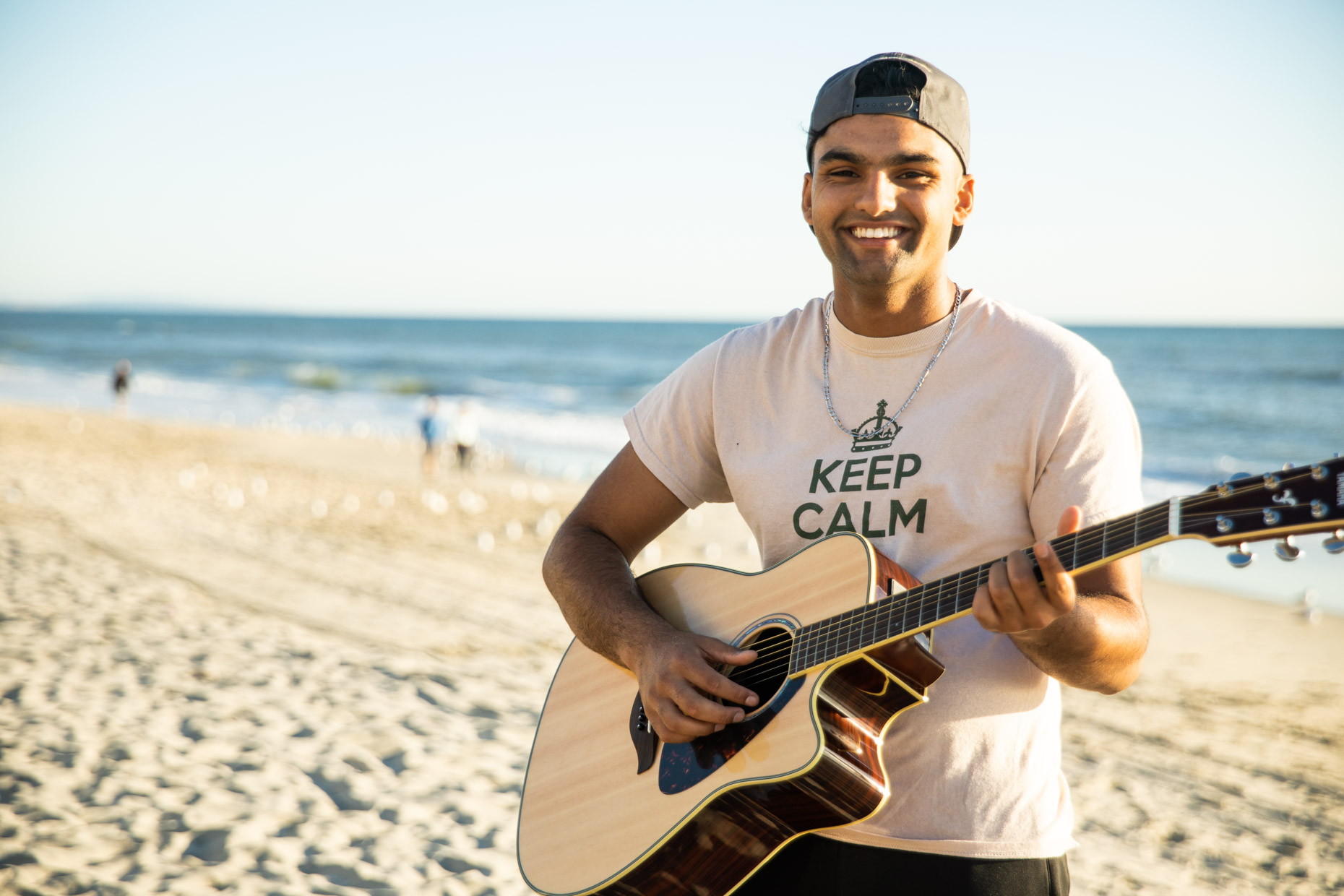 Portrait of young man playing guitar on beach