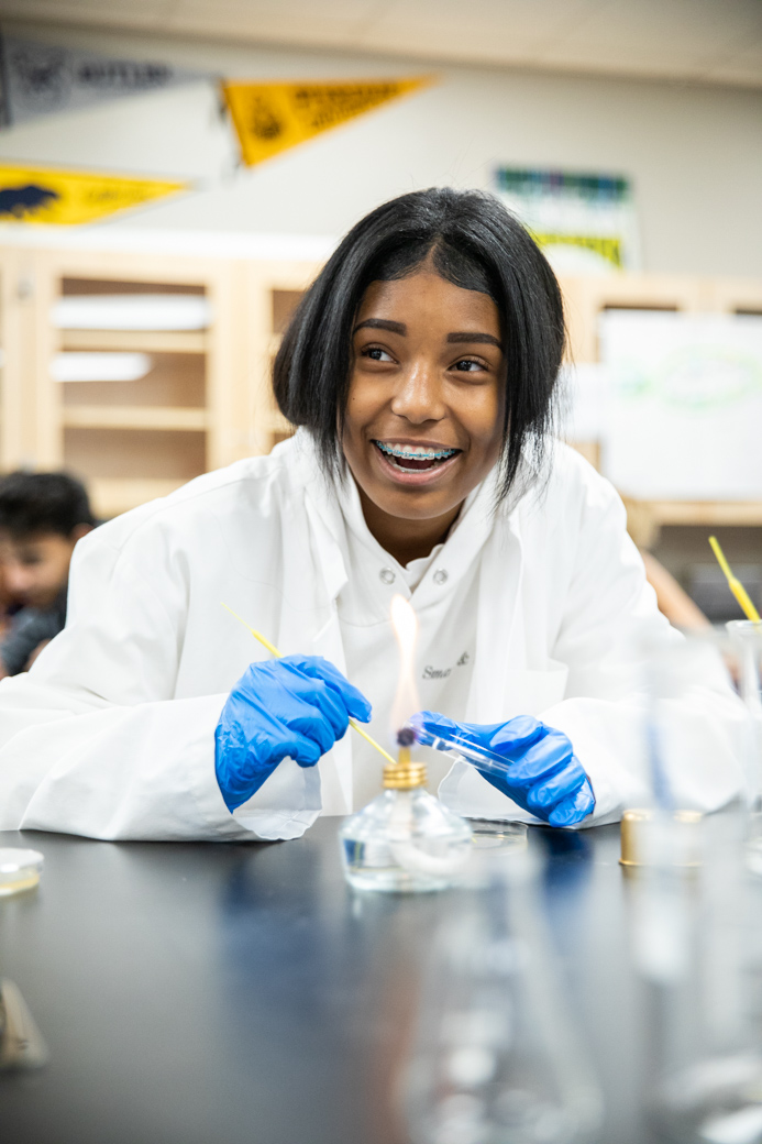 Female African American student in science lab with lab coat